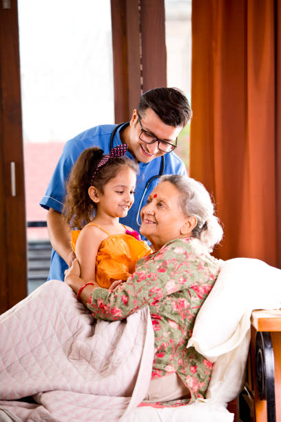 male nurse and granddaughter with her grandmother patient at home